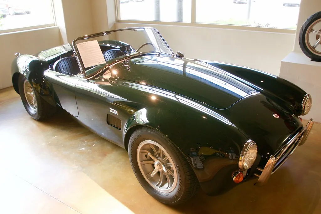 Un roadster clásico verde oscuro exhibido en una sala privada