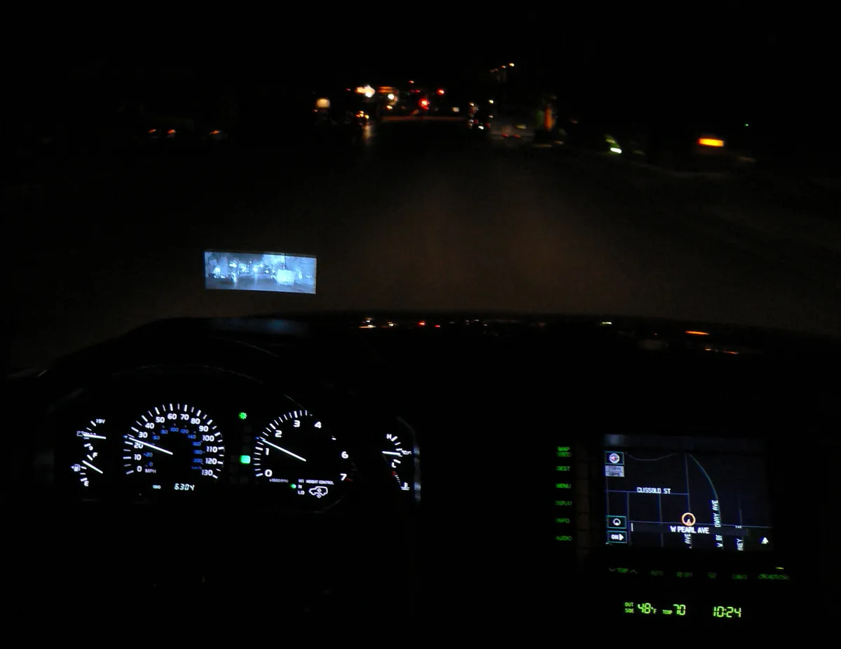 Illuminated dashboard instruments seen through a car windshield at night